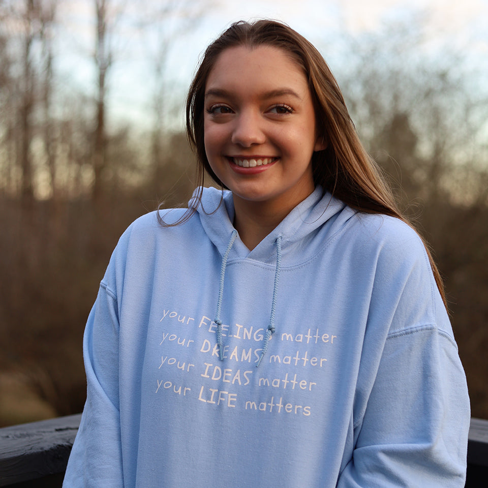 Your Life Matters Hoodie in Blue featuring a short description of the product and model wearing the item as well.